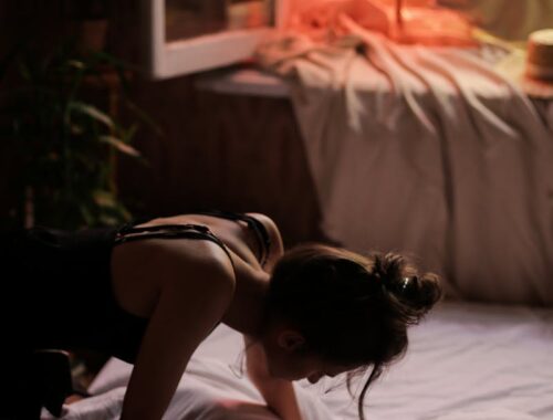 Woman in White Tank Top Lying on Bed