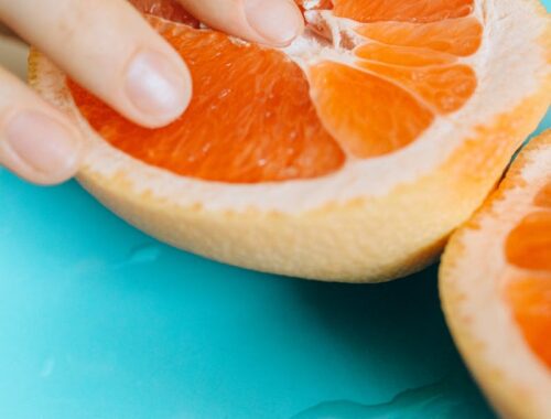 Person Touching Sliced Orange Fruit