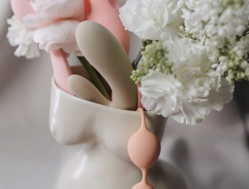 Colored Plastic Toys with Flowers in Clay Vase Shaped like Naked Woman